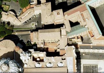 Aerial view of the Sistine Chapel (rectangular building in the center), with St. Peter's Basilica visible to the south.